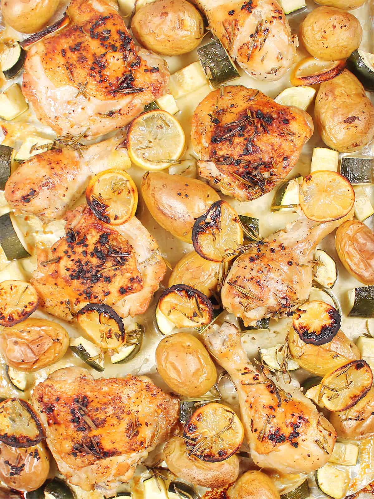 Closeup of baked rosemary lemon chicken thighs and legs.