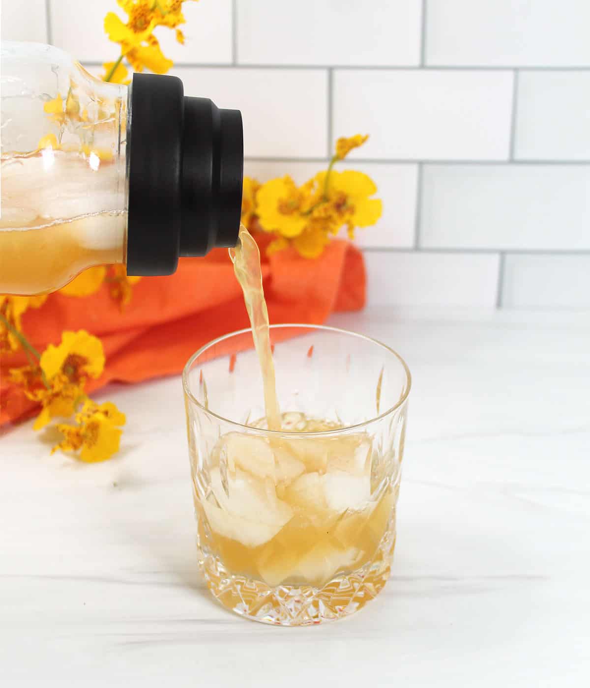 Pouring amaretto sour drink over ice.