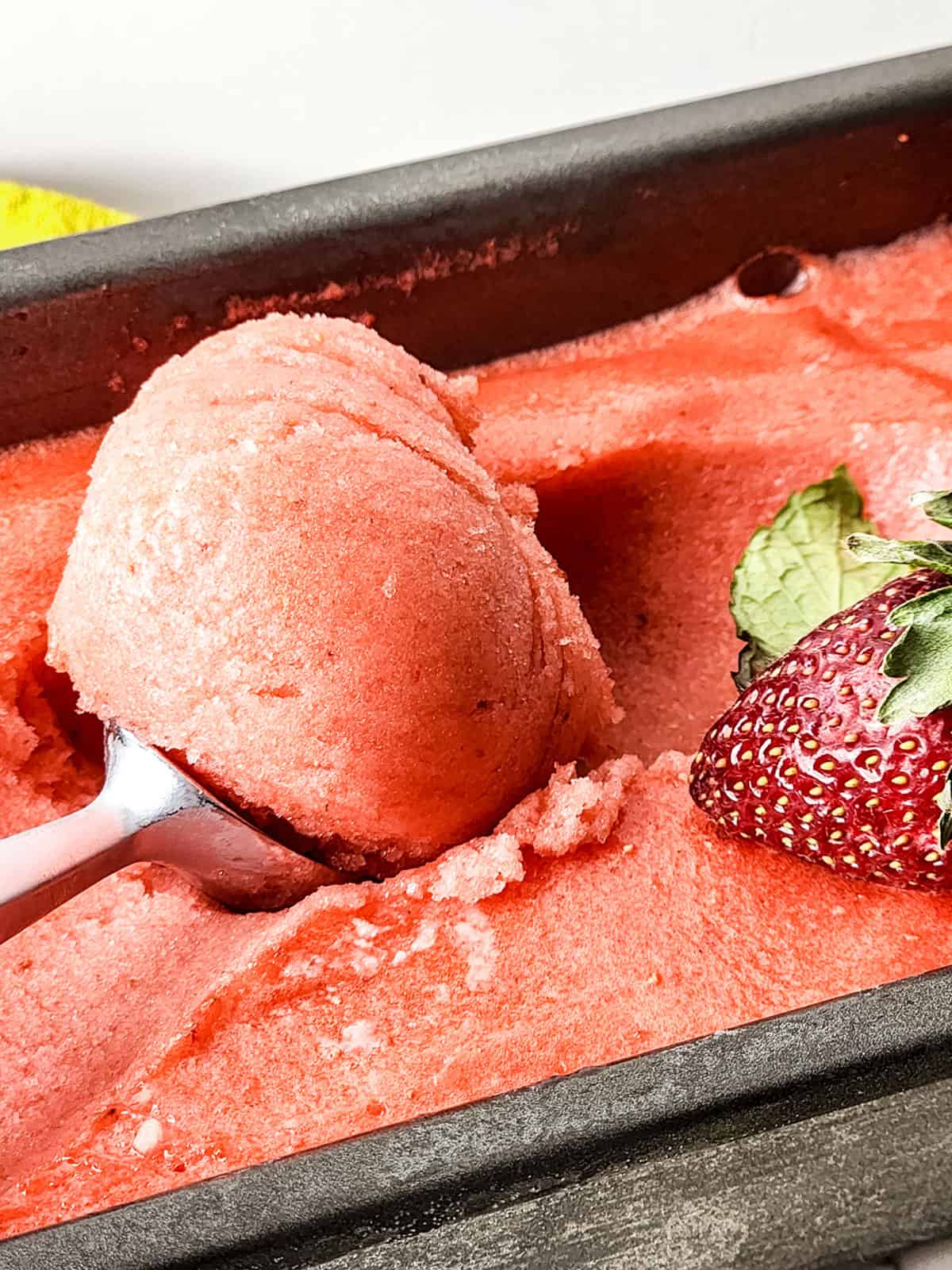 Scooping finished sorbet from loaf pan.