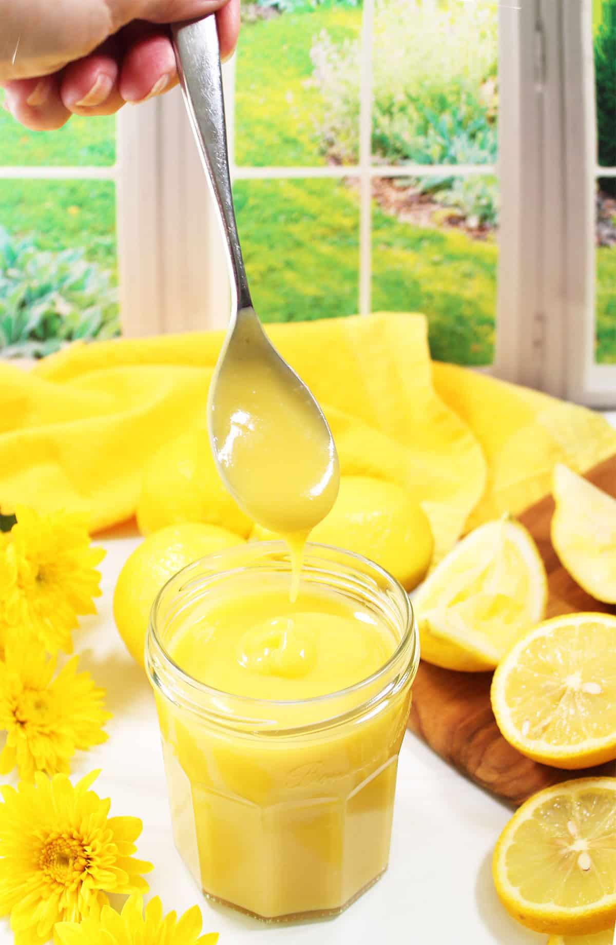 Smooth and creamy lemon curd dripping off spoon.