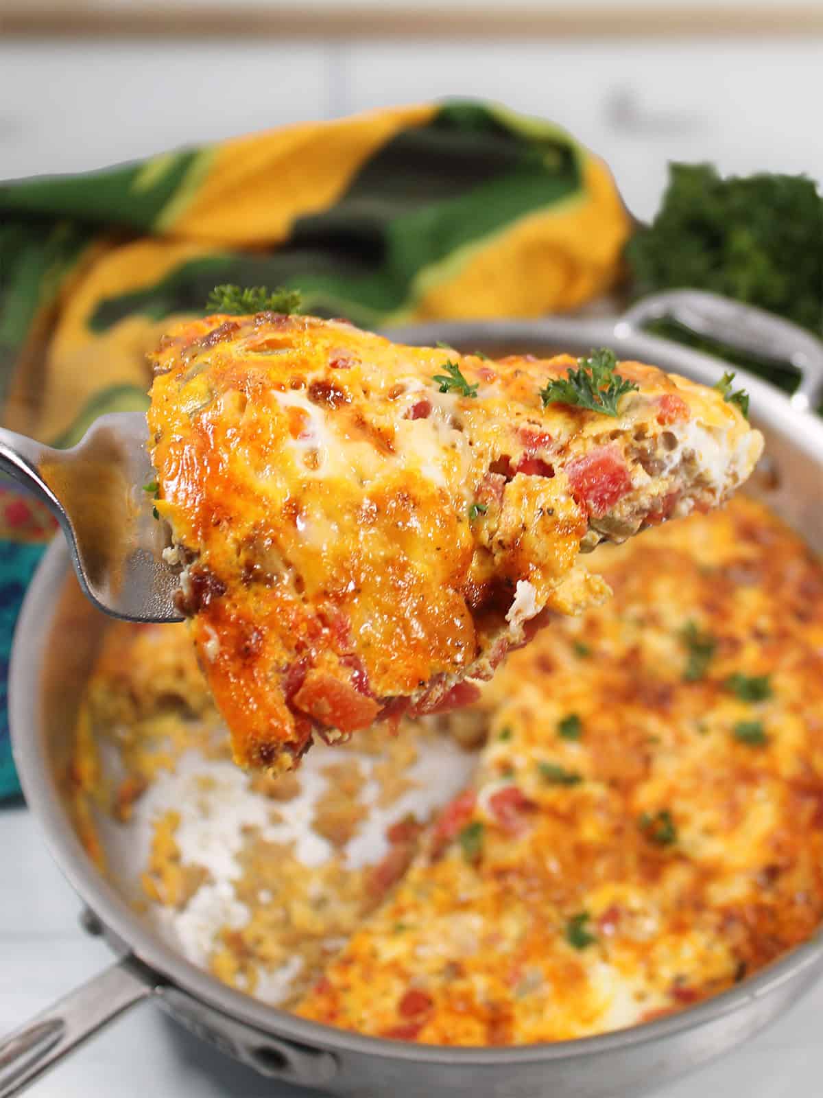 Holding a slice of frittata over skillet.