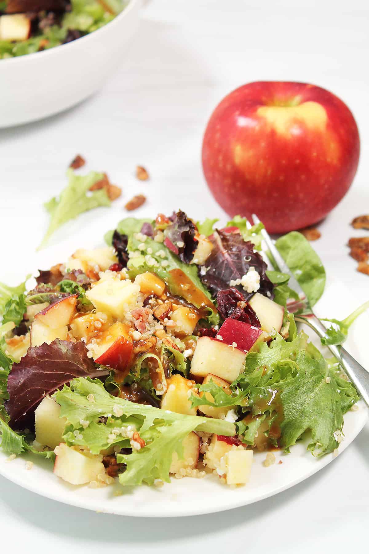 Plated fall salad with apple in back.