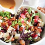 Drizzling bacon vinaigrette over apple pecan salad.