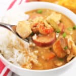 Spoonful of Chicken Sausage and Shrimp Grumbo over bowl.