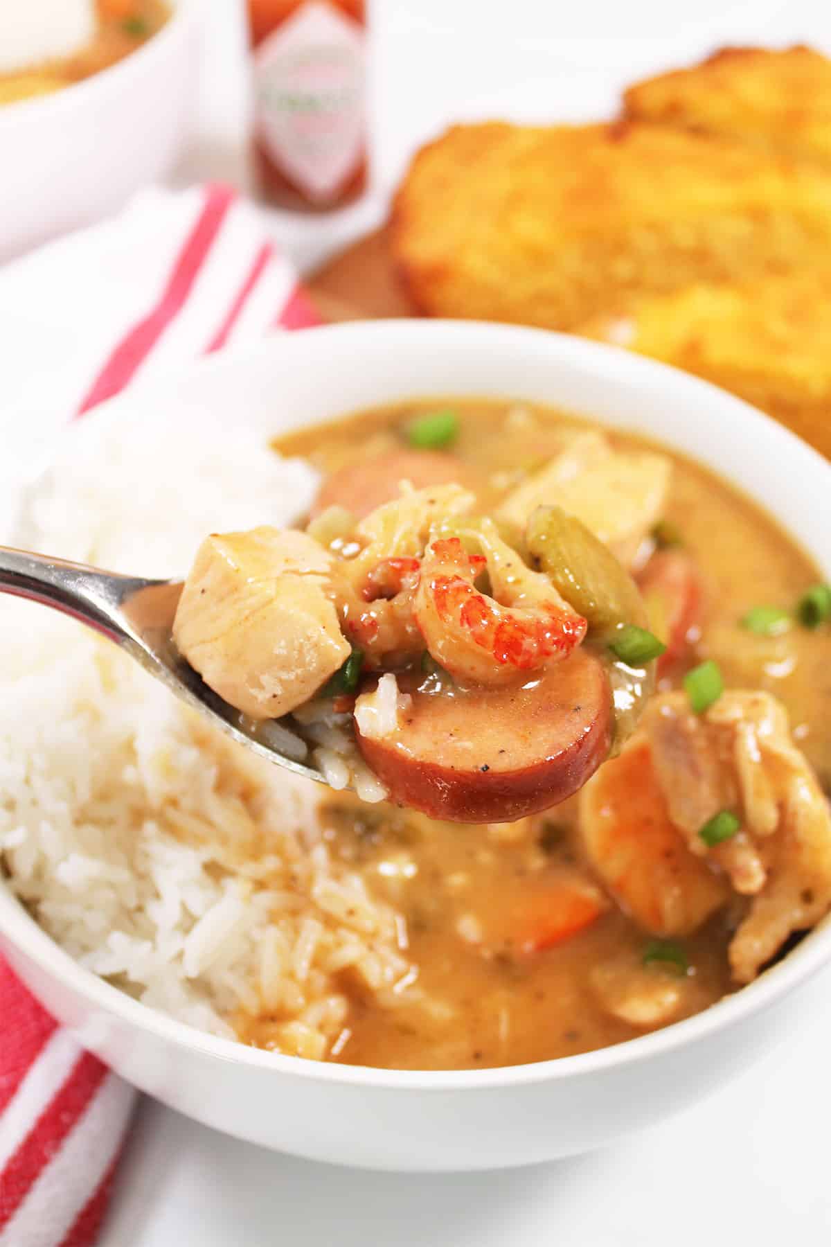 Spoonful of gumbo with shrimp, chicken and andouille.