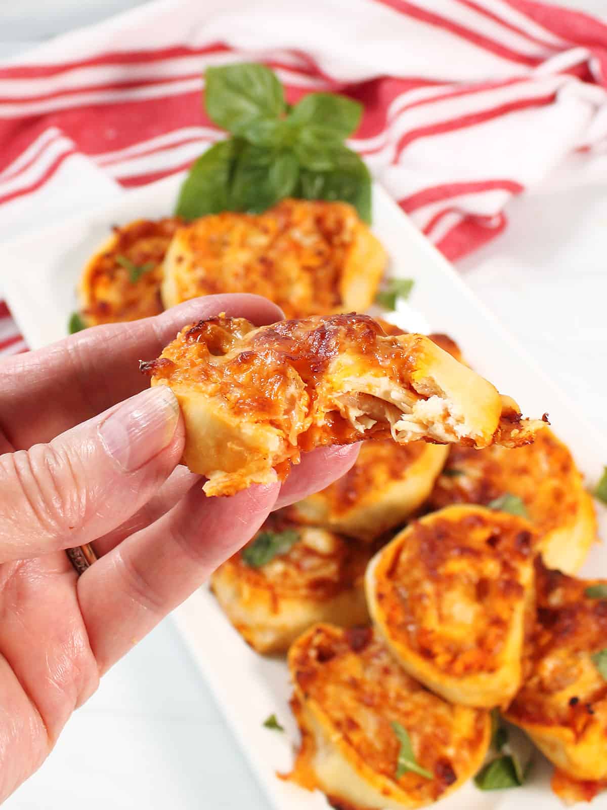 Holding chicken pinwheel with bite out.