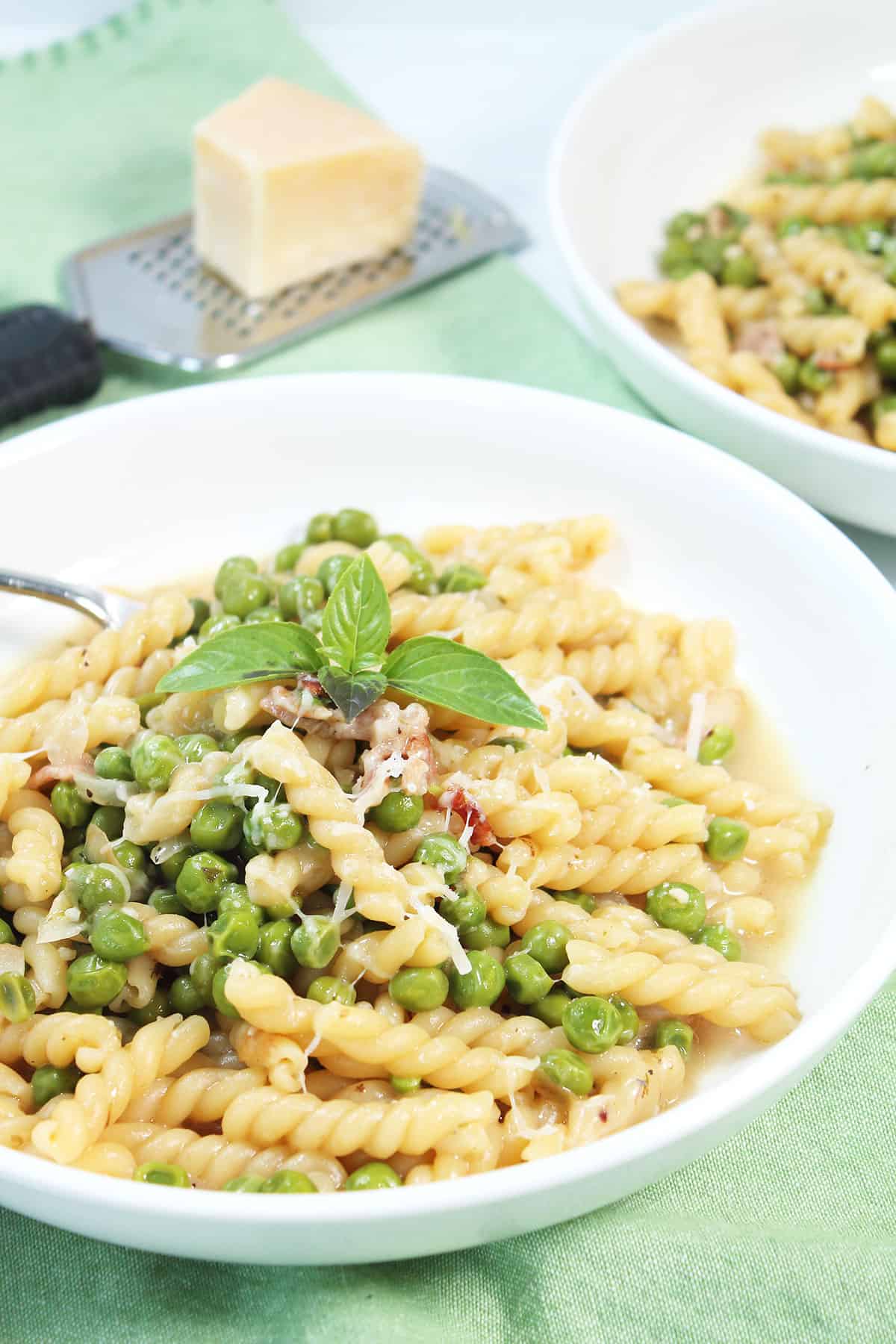 Bowlful of Pasta with Peas with basil garnish.