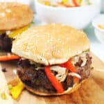 Closeup of grilled Korean burger on a bun with slaw.