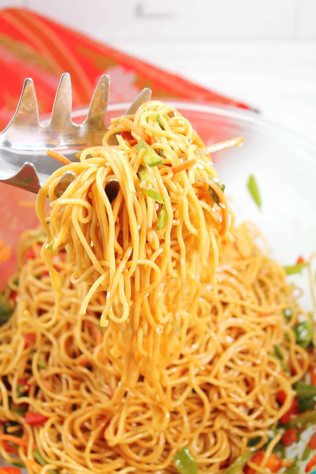 Scooping cold noodle salad out of bowl.