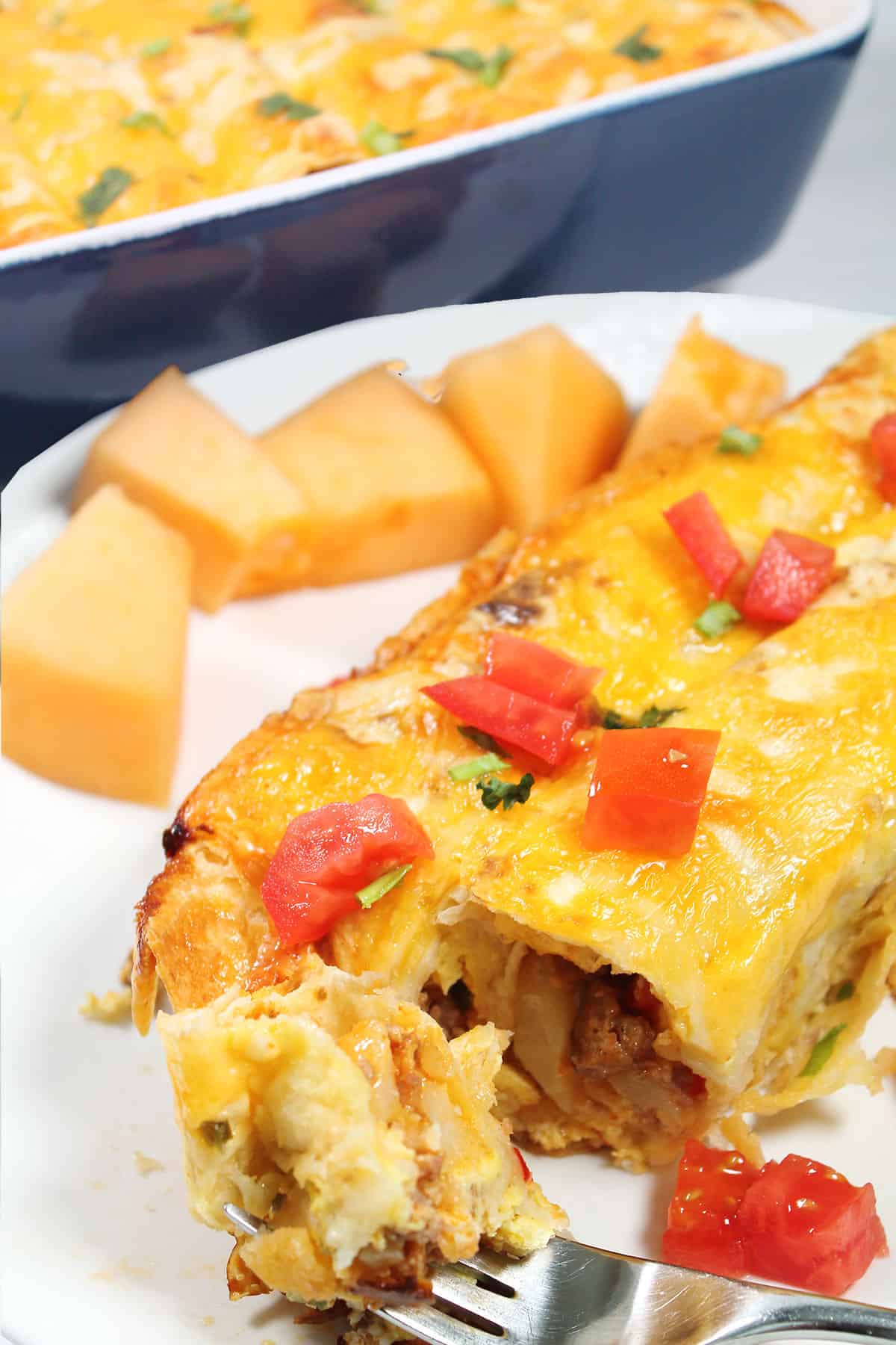 Breakfast Enchiladas plated with bite on fork.