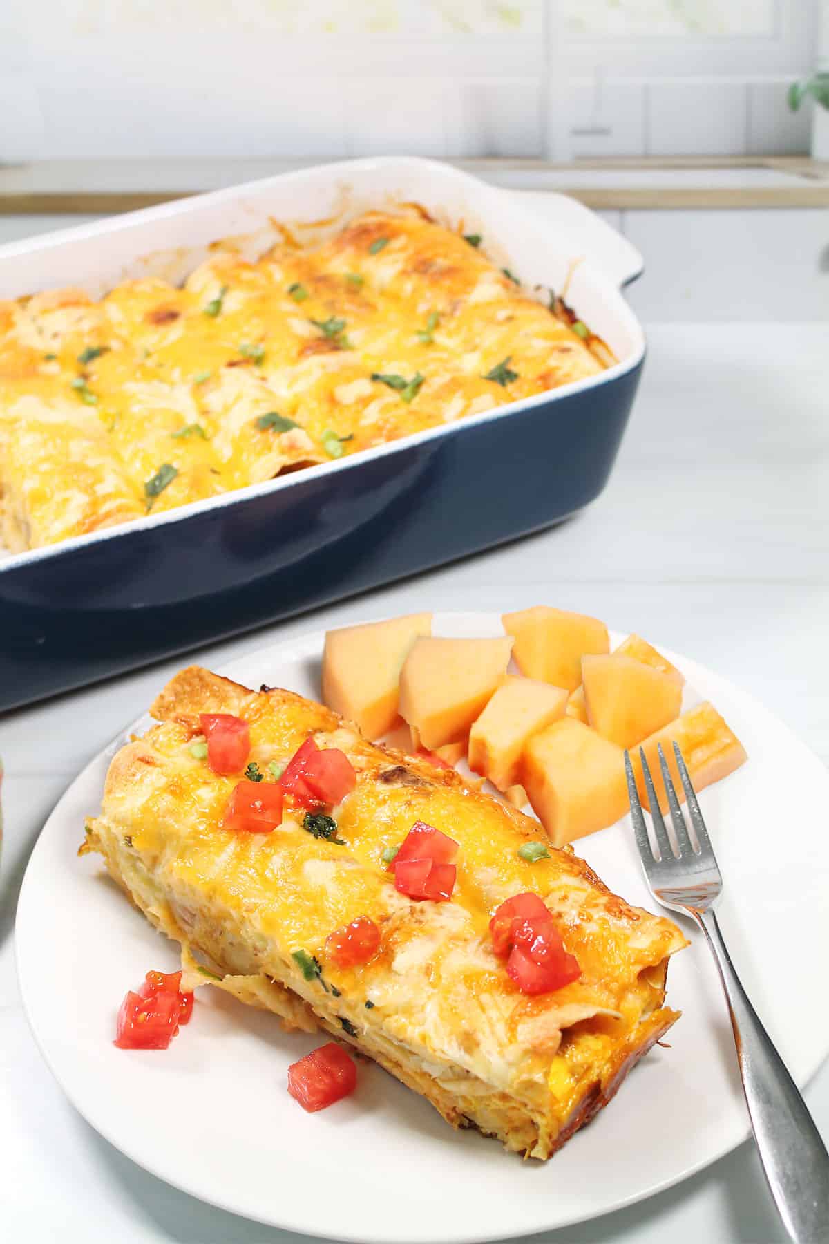 Plated Breakfast Enchiladas in front of casserole.