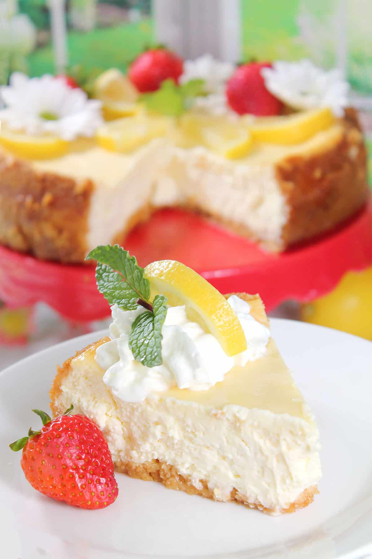 Slice of lemon cheesecake in front of sliced cake.