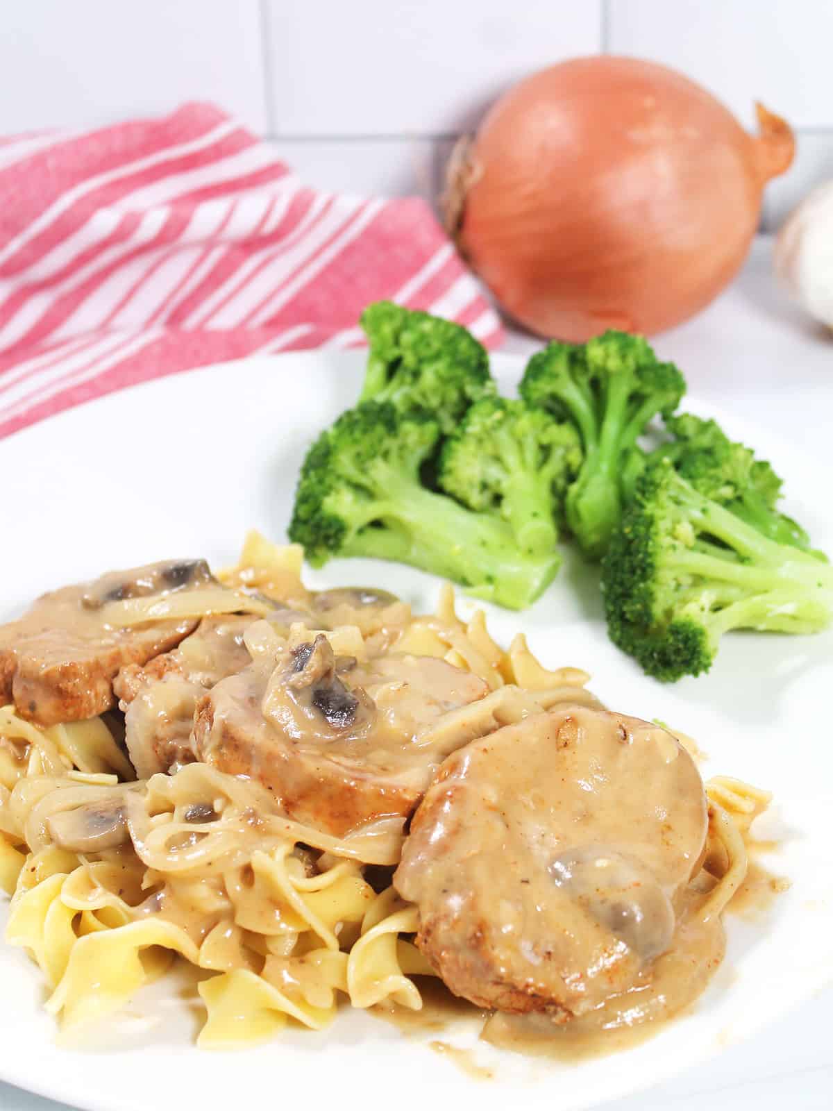 Pork Medallions in mushroom sauce plated over noodles.
