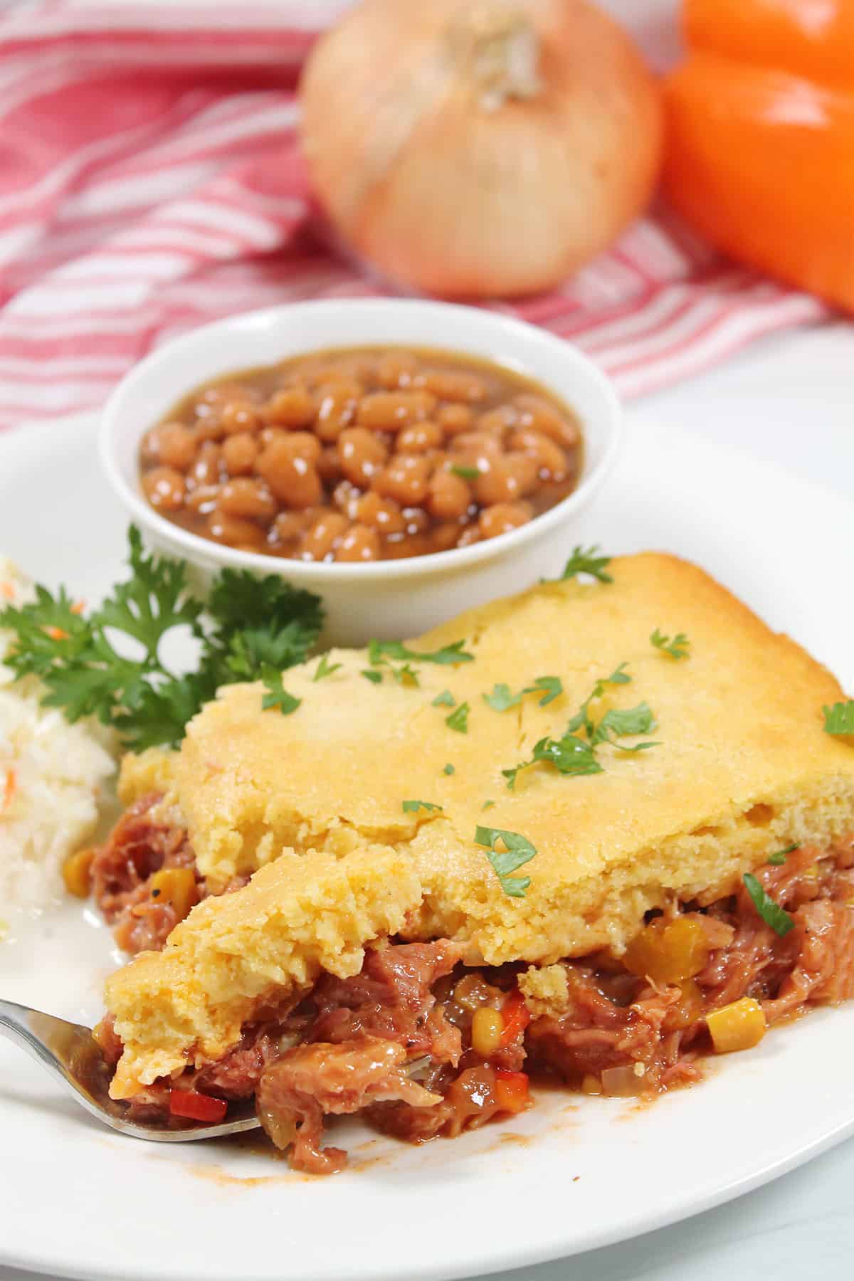 Pulled Pork Casserole with cornbread topping serving plated with bite on fork.