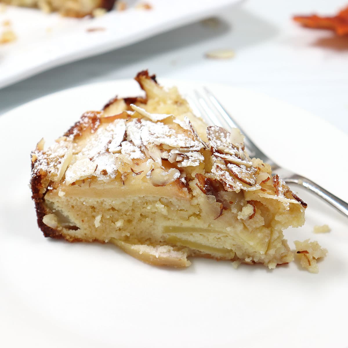 Slice of almond flour apple cake on plate.