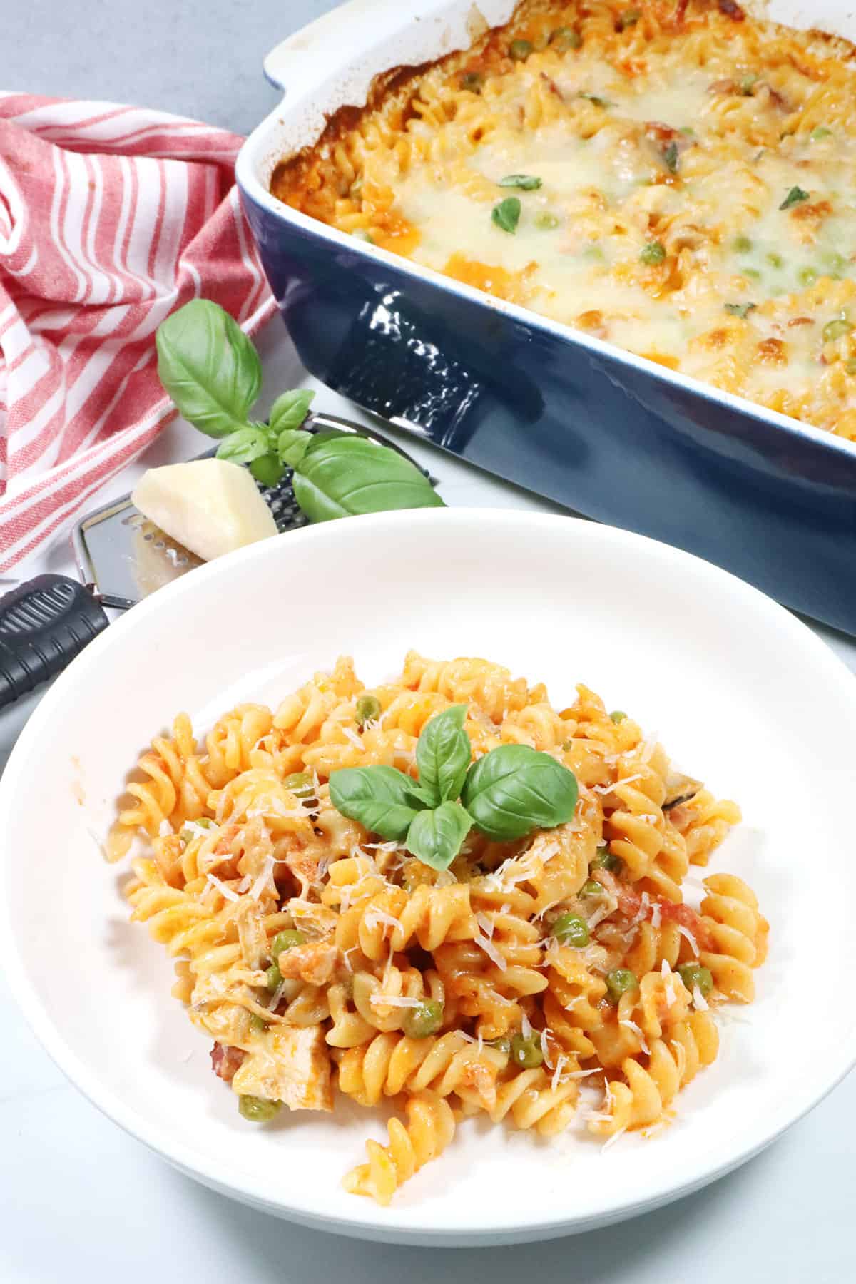 Chicken and Pasta with Vodka Sauce Casserole serving in a bowl with casserole in back.