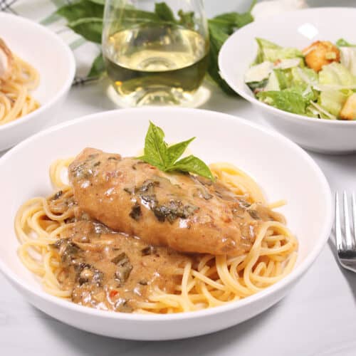 Chicken in basil cream sauce over pasta.