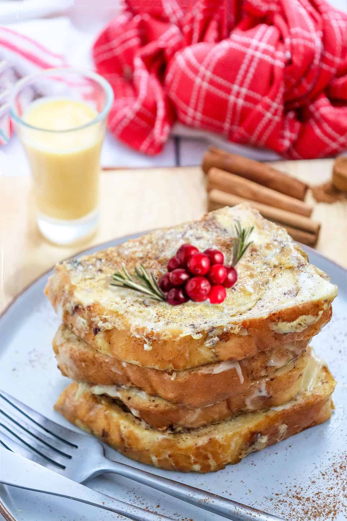Stacked Eggnog French Toast with cranberry garnish.