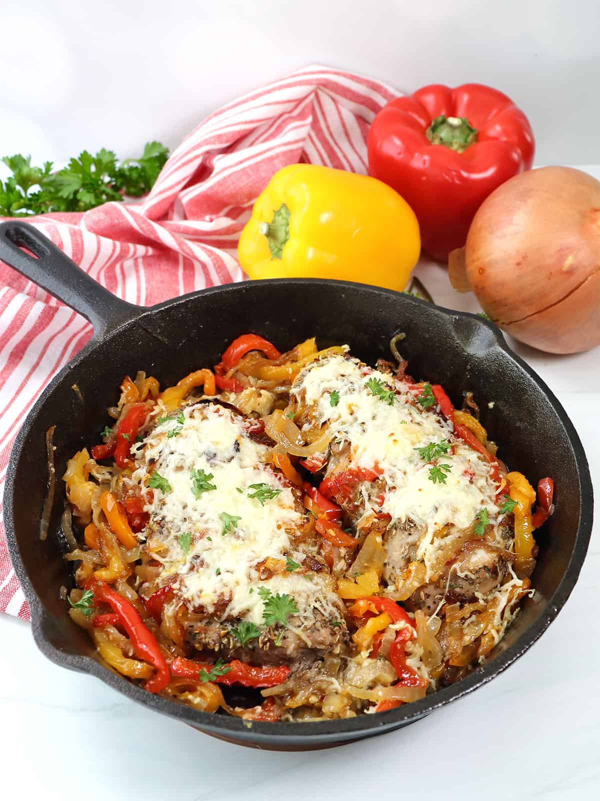 Cooked hasselback pork tenderloins in iron skillet.