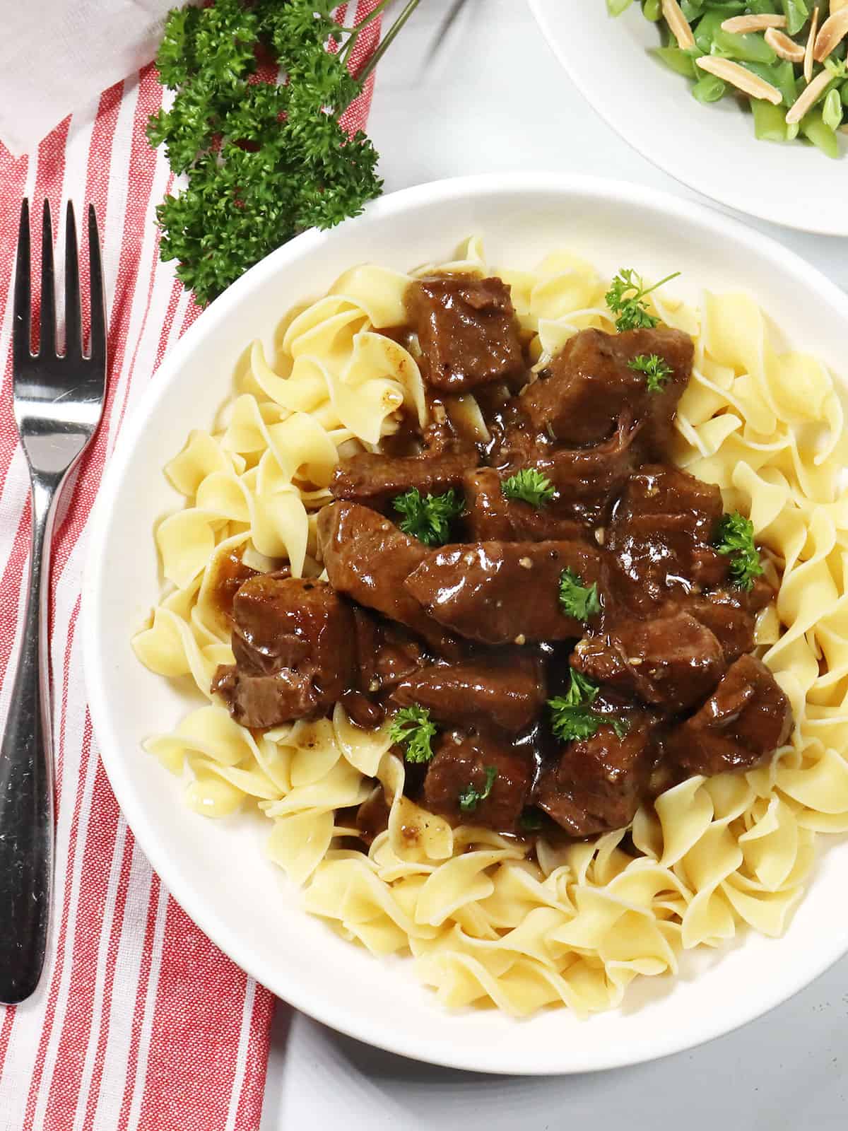 Instant Pot Beef Tips and gravy over egg noodles.
