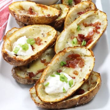 Stacked Air Fryer Potato Skins on platter.
