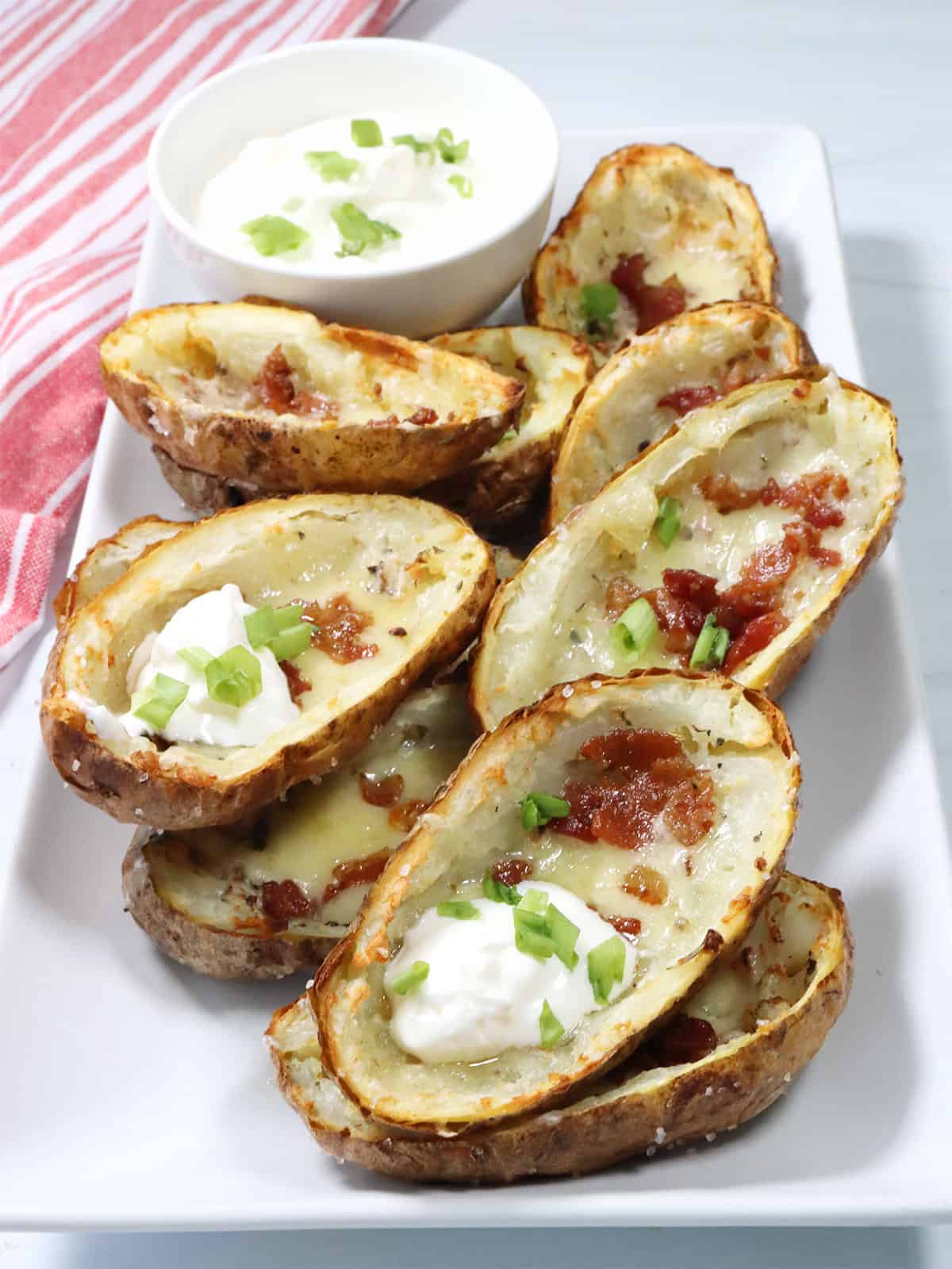 Air Fryer Potato Skins on platter with sour cream.