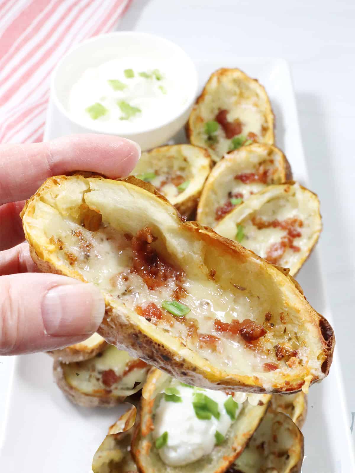 Holding one air fryer potato skin.