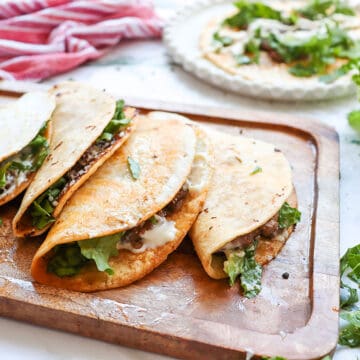 Caesar Salad Tacos meets smash burgers on wooden board.