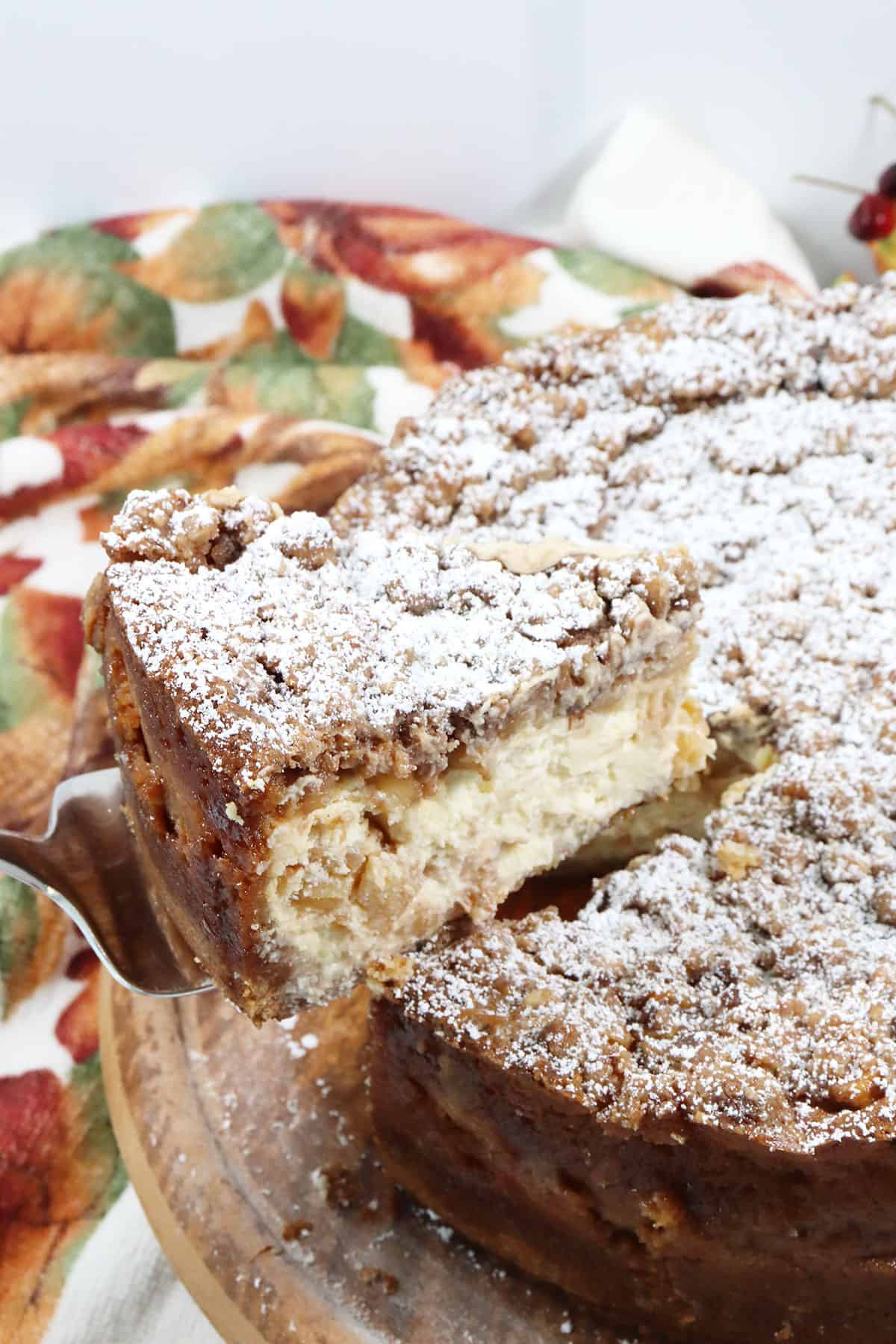 Lifting slice from apple cheesecake.