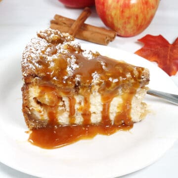 Slice of apple crumble cheesecake drizzled with caramel.