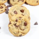 Soft and chewy chocolate chip cookies stacked with one leaning.