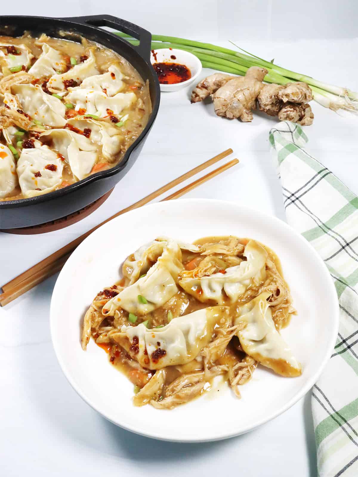 A bowlful of dumpling bake with full skillet in back.