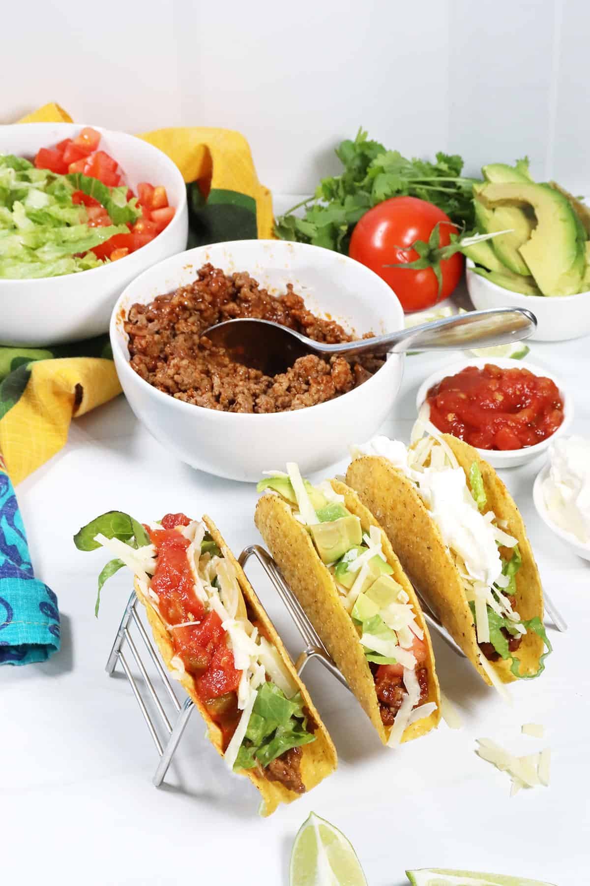 Tacos on stand with fillings in bowls.