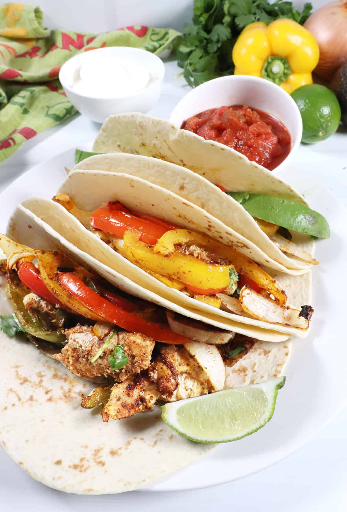 Fajitas wrapped in warm tortillas with garnishes.